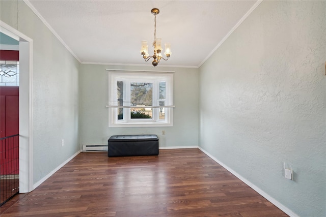 empty room with baseboard heating, ornamental molding, dark hardwood / wood-style floors, and an inviting chandelier