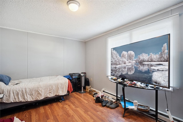 bedroom with hardwood / wood-style floors, crown molding, and a textured ceiling