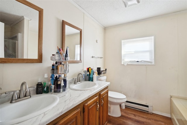 bathroom featuring toilet, a textured ceiling, baseboard heating, vanity, and hardwood / wood-style flooring