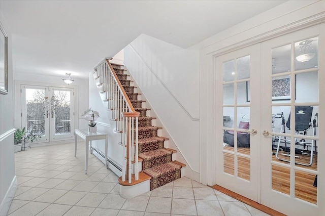 stairs with a baseboard heating unit, tile patterned floors, and french doors