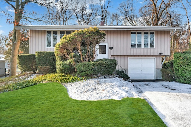 bi-level home featuring a garage and a front yard