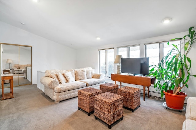 carpeted living room featuring a baseboard heating unit, lofted ceiling, and a healthy amount of sunlight