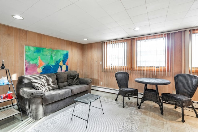 living room featuring wooden walls and baseboard heating