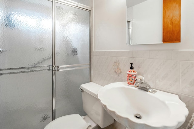 bathroom with tile walls, sink, toilet, and walk in shower