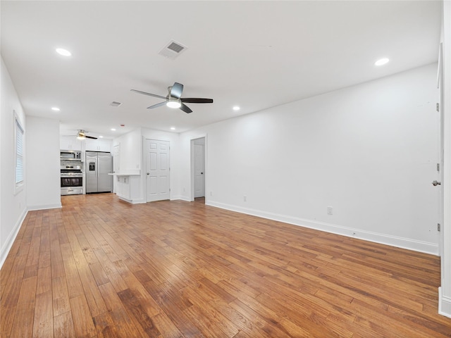 unfurnished living room featuring ceiling fan and light hardwood / wood-style floors