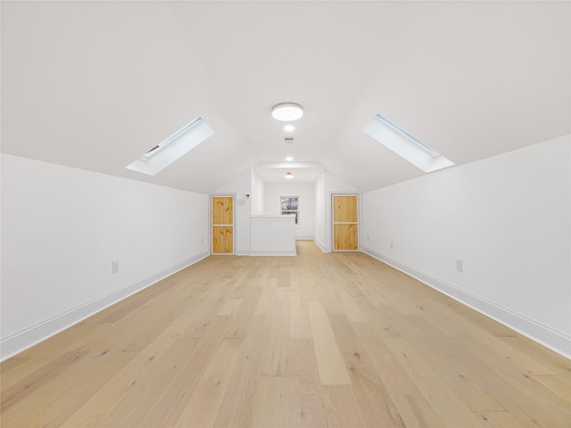 bonus room with lofted ceiling and light hardwood / wood-style flooring