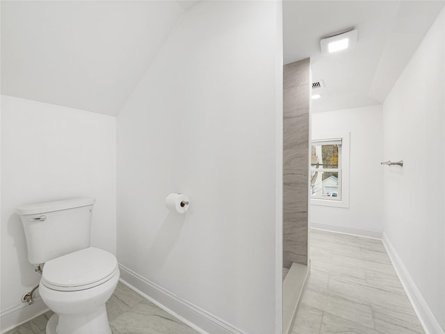 bathroom with lofted ceiling and toilet