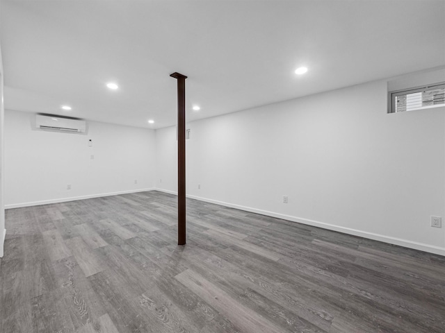 basement with hardwood / wood-style flooring and a wall mounted AC