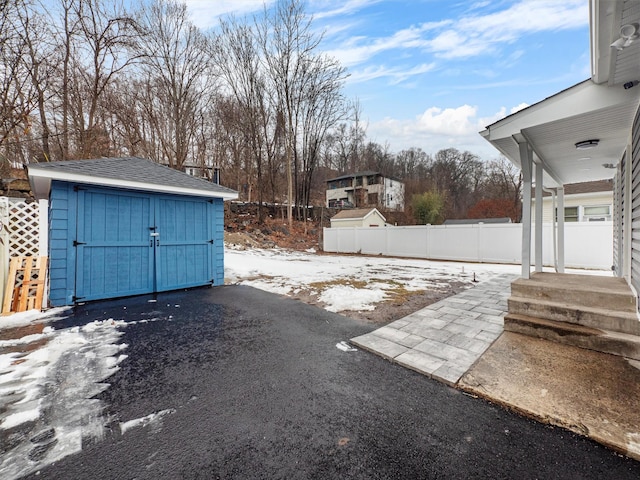 yard covered in snow with a storage unit