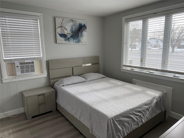 bedroom with multiple windows, cooling unit, and dark wood-type flooring