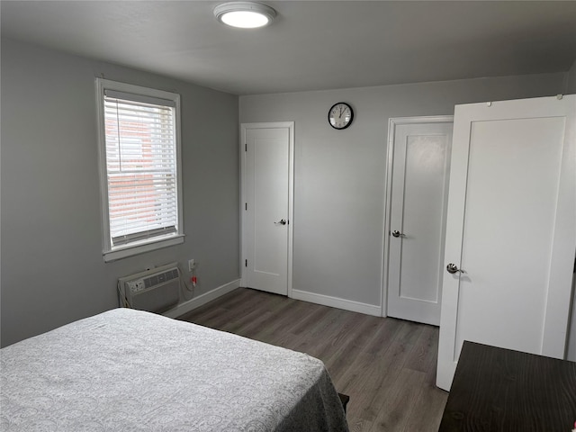 bedroom featuring an AC wall unit and dark hardwood / wood-style flooring