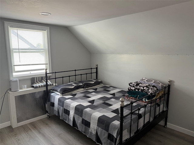 bedroom featuring wood-type flooring and vaulted ceiling