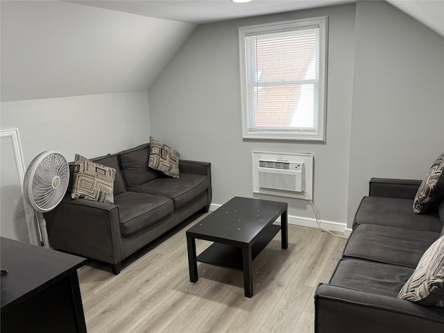 living room featuring lofted ceiling, light hardwood / wood-style floors, and a wall mounted AC