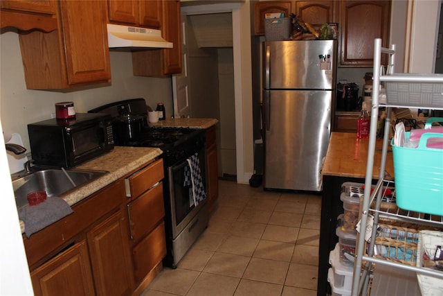 kitchen featuring appliances with stainless steel finishes, sink, and light tile patterned floors