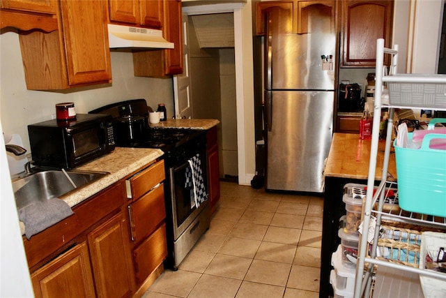 kitchen with stainless steel appliances, sink, and light tile patterned floors