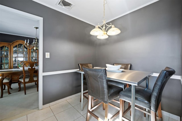 dining space with light tile patterned floors, crown molding, and a chandelier