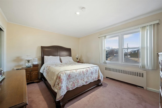 carpeted bedroom with radiator and ornamental molding