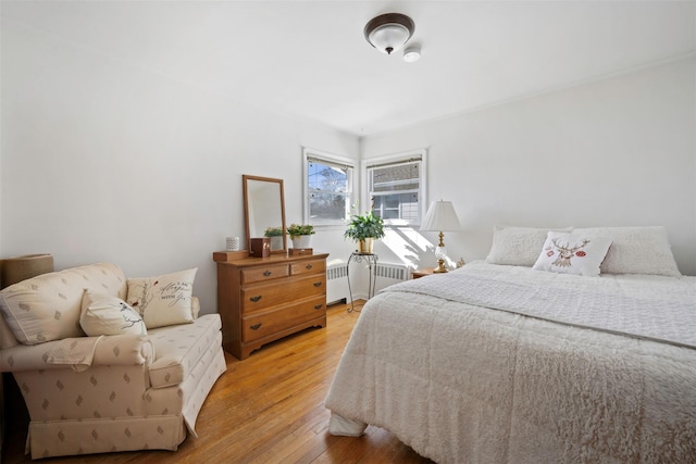 bedroom with radiator and light wood-type flooring