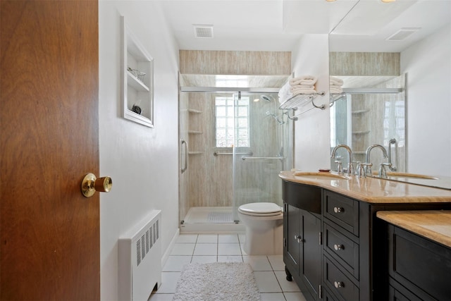 bathroom featuring vanity, a shower with door, radiator, and tile patterned flooring