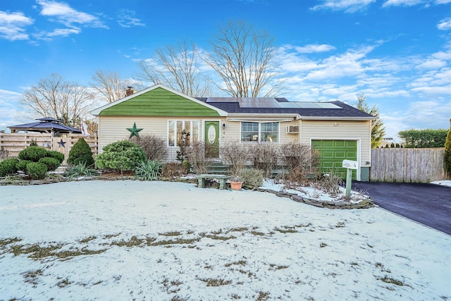 view of front of house featuring a garage and solar panels