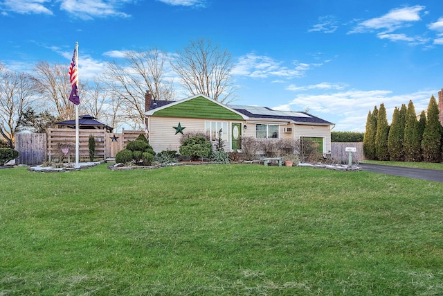 ranch-style home featuring a gazebo, a front lawn, and solar panels