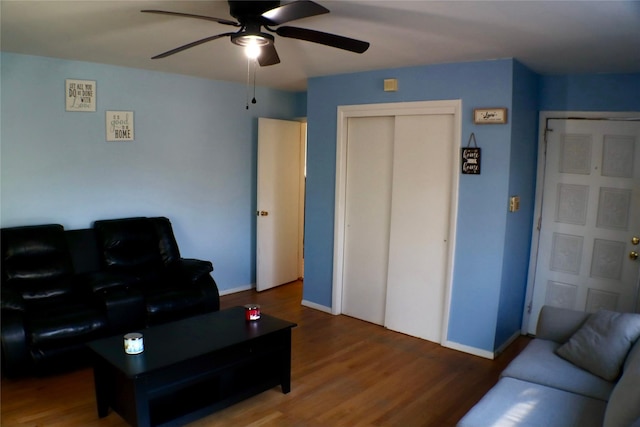 living room featuring wood finished floors, baseboards, and ceiling fan