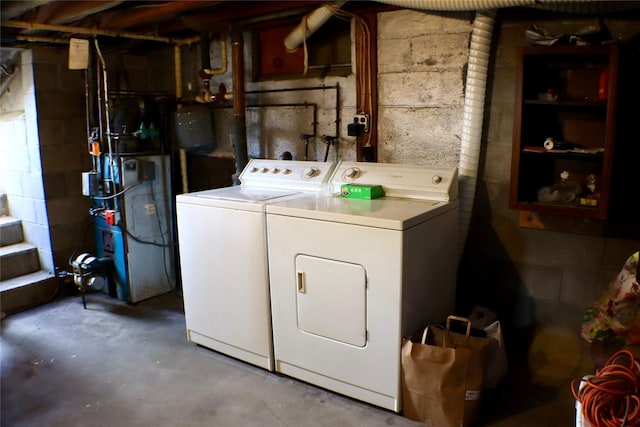 washroom featuring washing machine and dryer, laundry area, and a heating unit