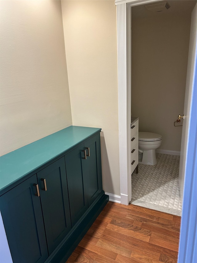 bathroom featuring vanity, toilet, and hardwood / wood-style floors