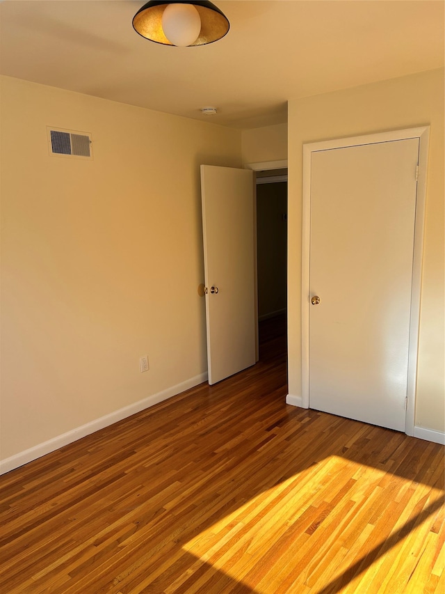 unfurnished bedroom featuring hardwood / wood-style floors and a closet