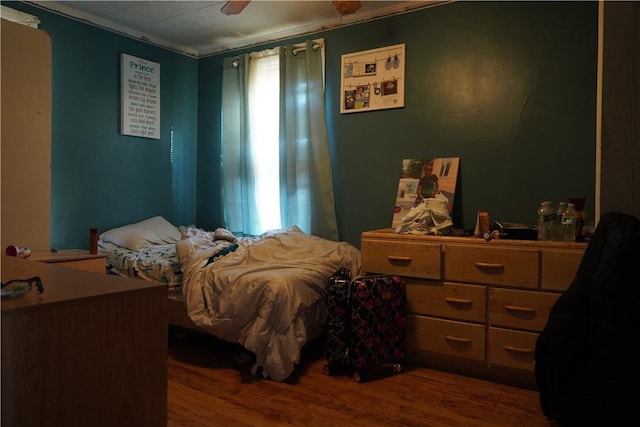 bedroom featuring hardwood / wood-style flooring, crown molding, and ceiling fan