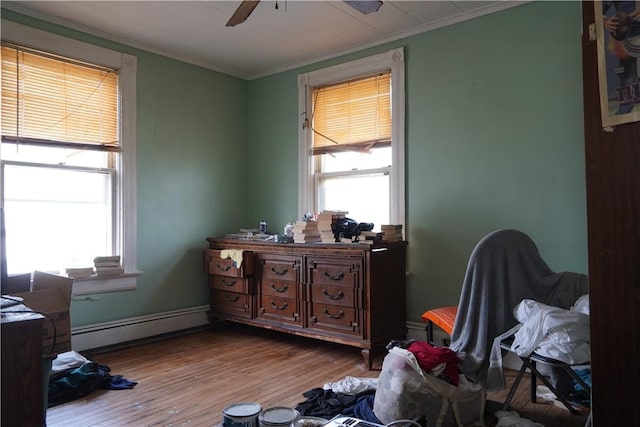 bedroom with ceiling fan, a baseboard radiator, ornamental molding, and light hardwood / wood-style floors