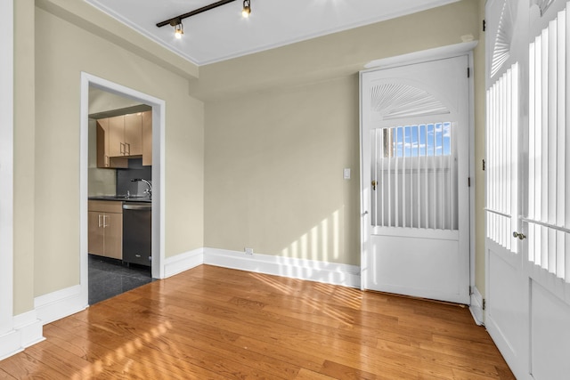 interior space with sink, hardwood / wood-style flooring, and rail lighting