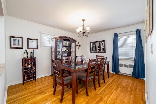 dining space featuring radiator, an inviting chandelier, and light hardwood / wood-style floors