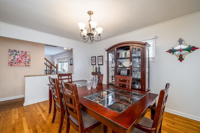 dining space with hardwood / wood-style flooring, a healthy amount of sunlight, and a chandelier