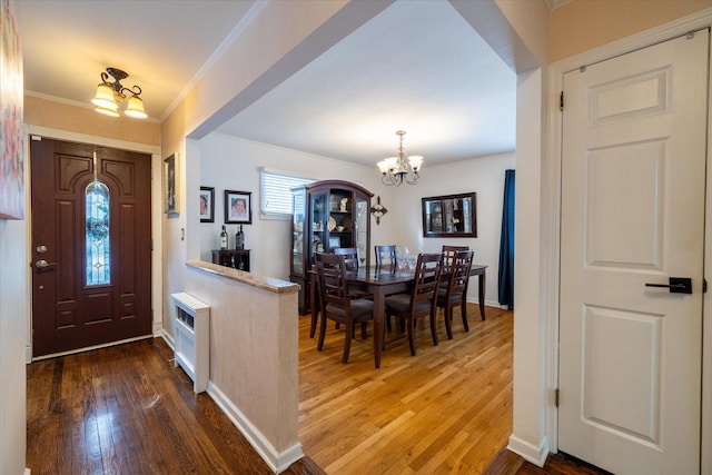 entrance foyer featuring hardwood / wood-style flooring, crown molding, and a notable chandelier