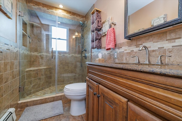 bathroom featuring tasteful backsplash, vanity, walk in shower, baseboard heating, and toilet