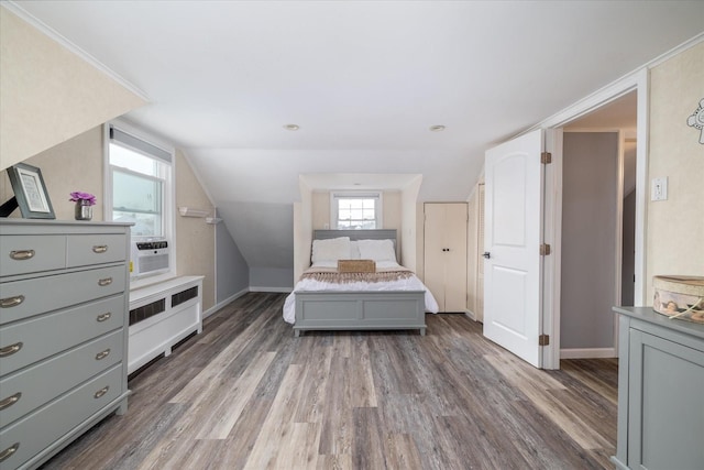 bedroom with hardwood / wood-style flooring, vaulted ceiling, and cooling unit