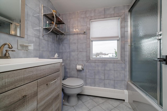 full bathroom featuring shower / bath combination with glass door, baseboard heating, tile walls, tile patterned flooring, and toilet