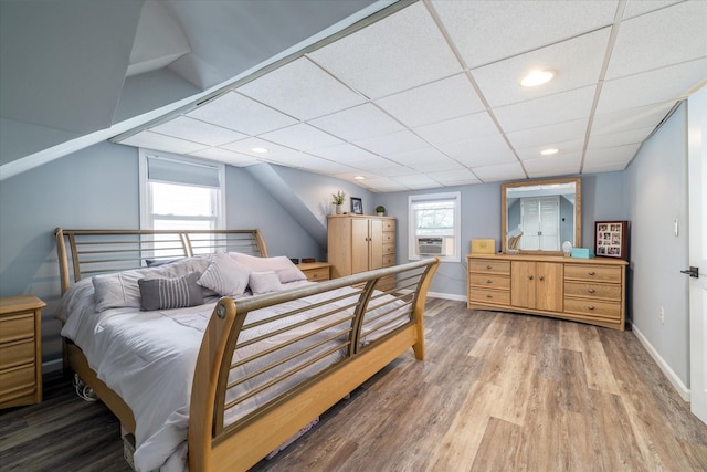 bedroom with cooling unit, hardwood / wood-style floors, and a paneled ceiling