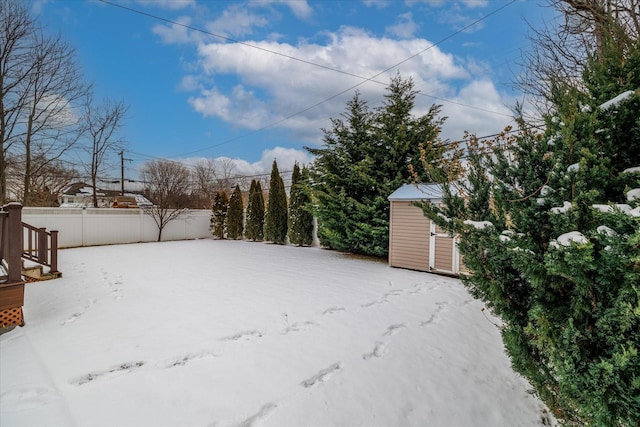 yard covered in snow featuring a shed