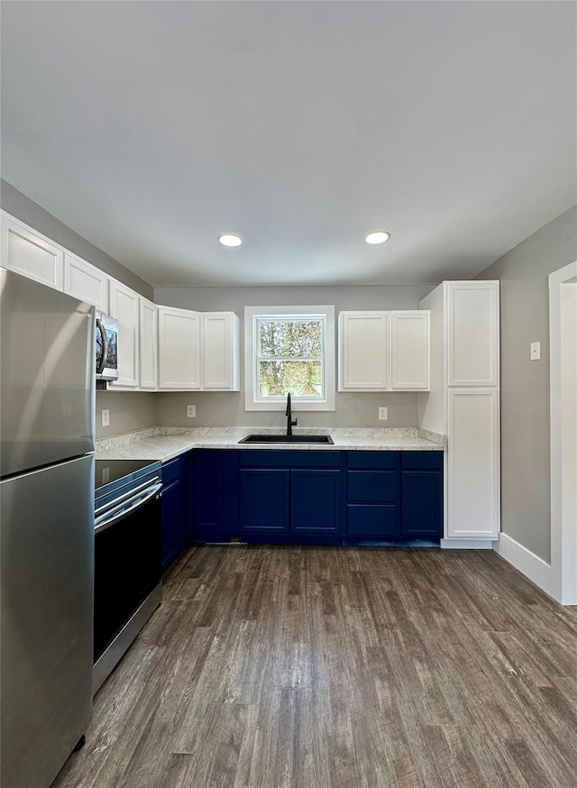 291 Clements Rd, Liberty, NY 12754 - kitchen with white cabinets, a sink, dark wood finished floors, stainless steel appliances, and blue cabinets