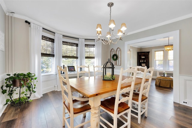 dining space featuring crown molding, a healthy amount of sunlight, dark wood-type flooring, and an inviting chandelier