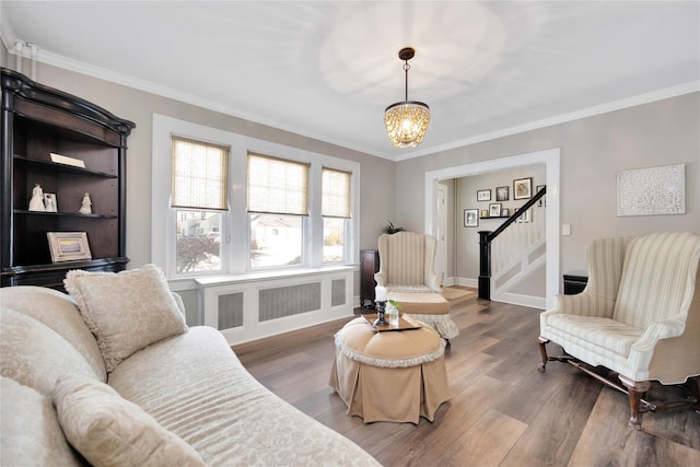 living room featuring a notable chandelier, crown molding, and wood-type flooring