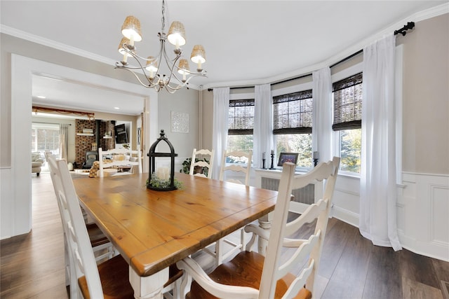 dining room featuring crown molding, an inviting chandelier, and dark hardwood / wood-style flooring