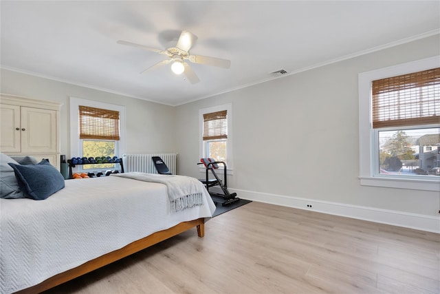 bedroom with ceiling fan, radiator heating unit, light hardwood / wood-style floors, and ornamental molding