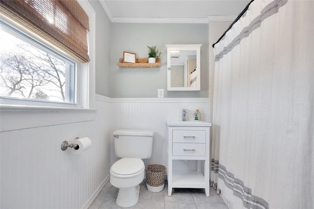 bathroom featuring tile patterned floors, ornamental molding, and toilet