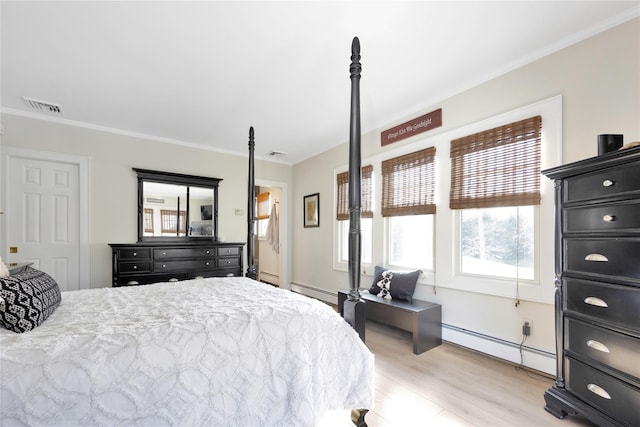 bedroom with baseboard heating, ornamental molding, and light hardwood / wood-style floors