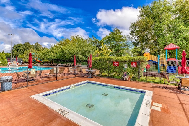 view of pool featuring a playground and a patio