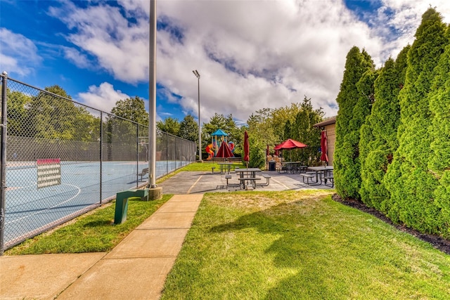 view of sport court featuring a playground and a lawn