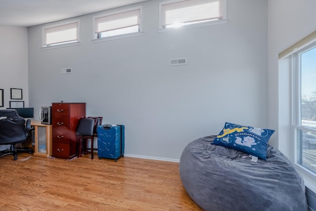 home office with wood-type flooring and a healthy amount of sunlight